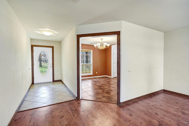 entrance foyer featuring a notable chandelier, light hardwood / wood-style flooring, and a wealth of natural light