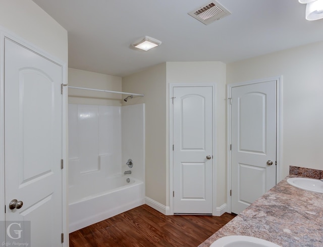 bathroom featuring vanity, wood-type flooring, and bathing tub / shower combination