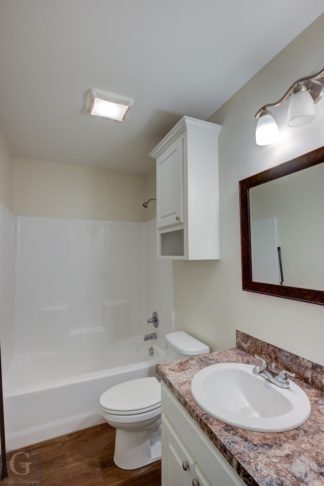 full bathroom with vanity, hardwood / wood-style floors, shower / bathing tub combination, and toilet