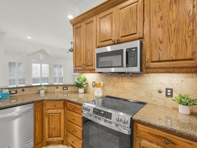 kitchen with backsplash, ceiling fan, stone counters, and appliances with stainless steel finishes