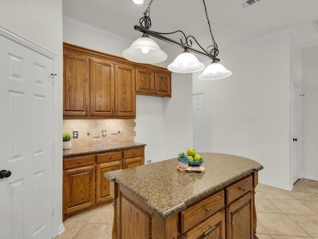 kitchen with hanging light fixtures, a center island, light stone countertops, ornamental molding, and decorative backsplash