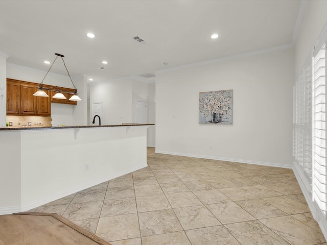 interior space featuring dark stone countertops, ornamental molding, decorative backsplash, a kitchen bar, and decorative light fixtures