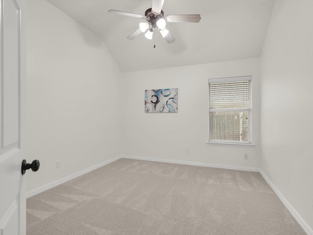 spare room with vaulted ceiling, light colored carpet, and ceiling fan