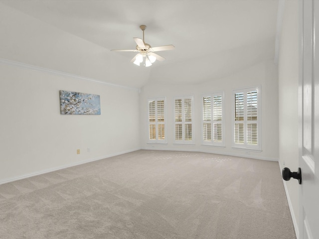 carpeted spare room featuring vaulted ceiling and ceiling fan