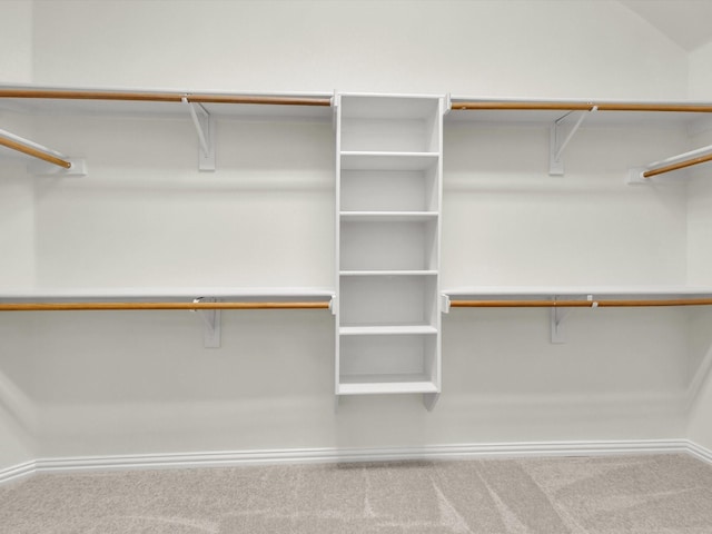 walk in closet featuring lofted ceiling and carpet floors