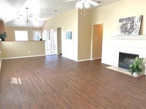 unfurnished living room with dark hardwood / wood-style flooring, vaulted ceiling, and ceiling fan