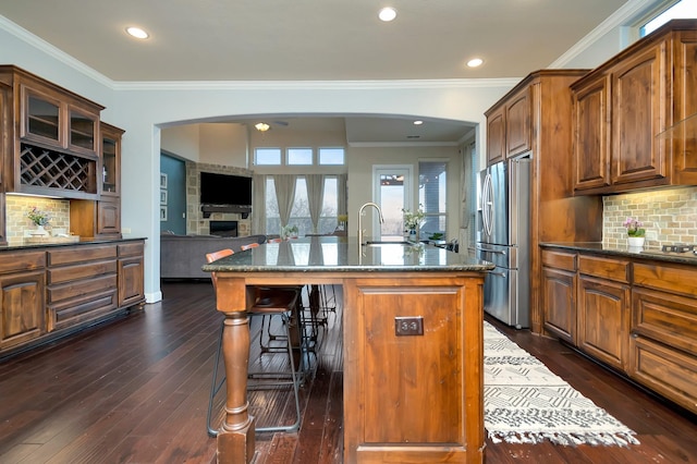 1844 Halifax St, Roanoke, TX 76262 - kitchen with stainless steel fridge, arched walkways, a sink, a breakfast bar area, and crown molding