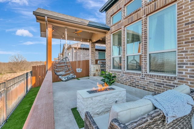 view of patio with a ceiling fan, an outdoor fire pit, and fence