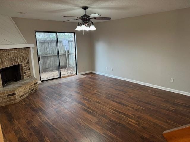 unfurnished living room featuring ceiling fan, dark hardwood / wood-style floors, a textured ceiling, and a fireplace