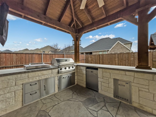 view of patio / terrace with area for grilling, a gazebo, ceiling fan, and an outdoor kitchen