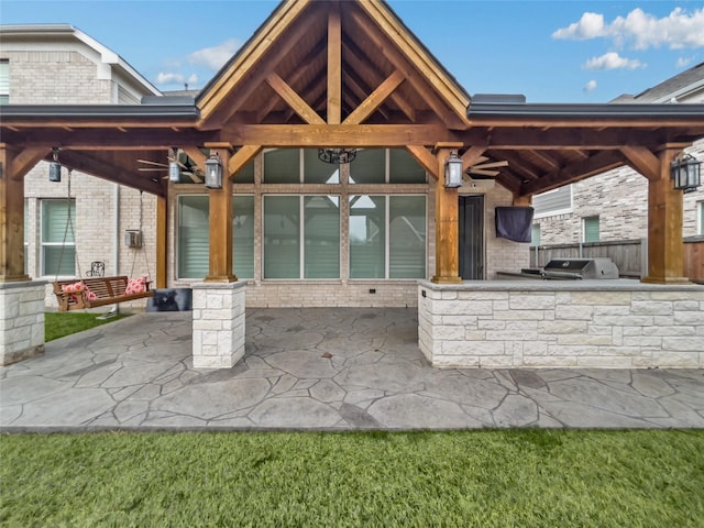 exterior space with grilling area, an outdoor kitchen, and ceiling fan