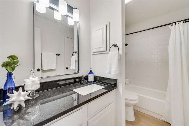 full bathroom with shower / tub combo with curtain, vanity, toilet, and hardwood / wood-style floors