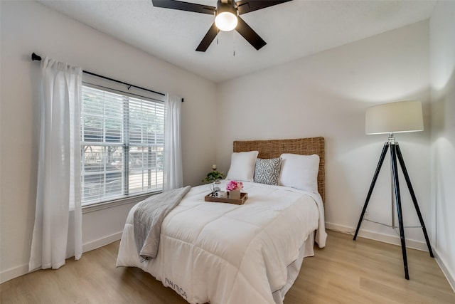 bedroom with ceiling fan and light wood-type flooring