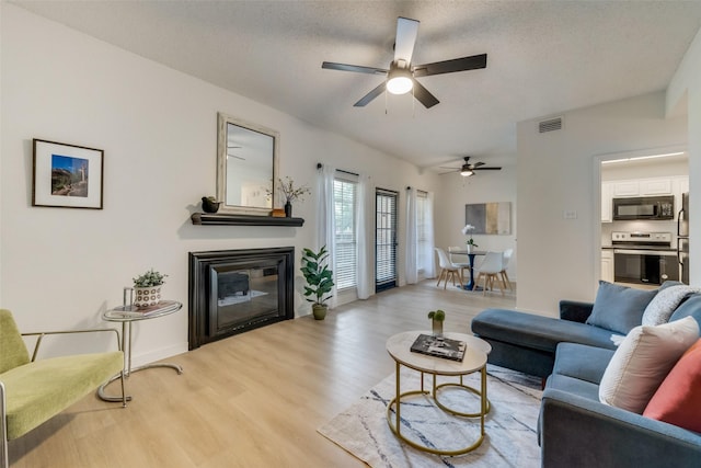 living room featuring light hardwood / wood-style flooring and a textured ceiling