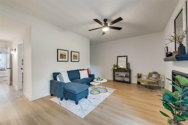 living room featuring light hardwood / wood-style flooring and ceiling fan