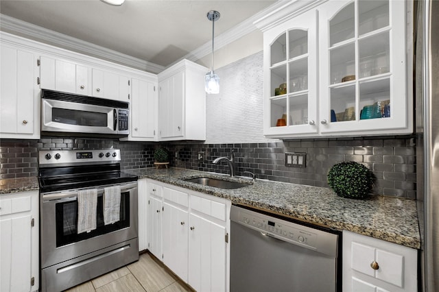 kitchen with dark stone countertops, stainless steel appliances, sink, and white cabinets