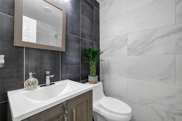 bathroom featuring vanity, tile walls, and toilet