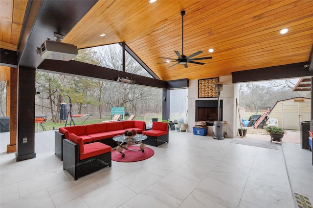 view of patio with ceiling fan, a storage shed, and an outdoor living space with a fireplace