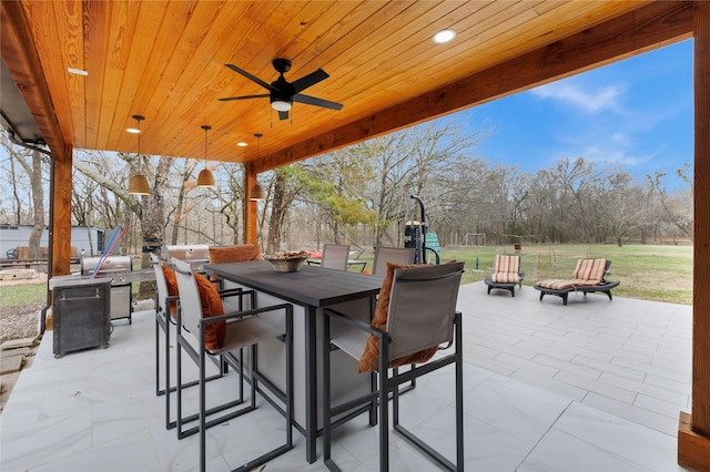 view of patio with a playground, ceiling fan, and an outdoor fire pit