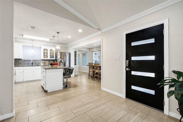 kitchen with a kitchen island, decorative light fixtures, tasteful backsplash, a breakfast bar area, and white cabinets