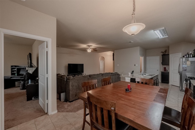 carpeted dining space featuring sink and ceiling fan