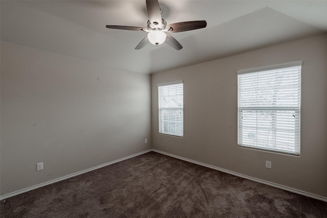 carpeted spare room featuring vaulted ceiling and ceiling fan