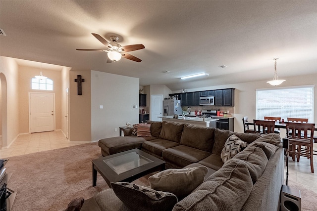 living room featuring ceiling fan, a textured ceiling, and light tile patterned flooring