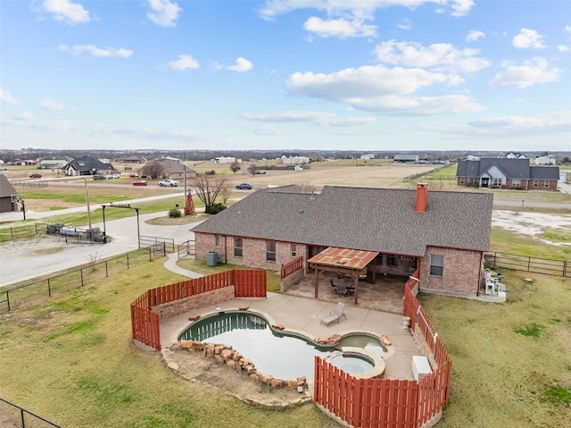 view of pool with fence private yard, a pool with connected hot tub, a patio area, and a yard