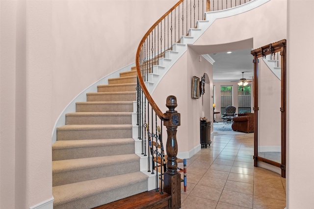 stairs with tile patterned flooring and a high ceiling