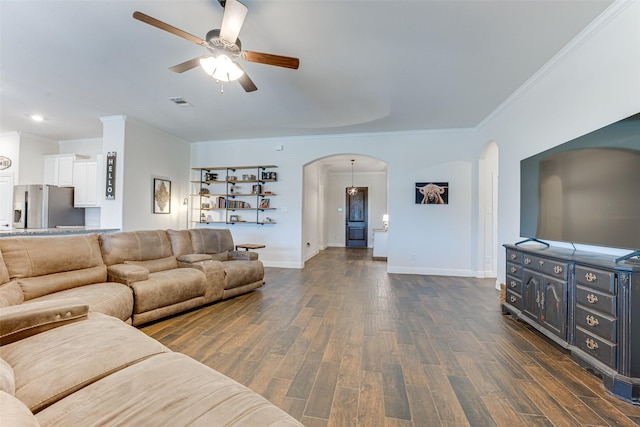 living room with dark wood-type flooring, ornamental molding, and ceiling fan