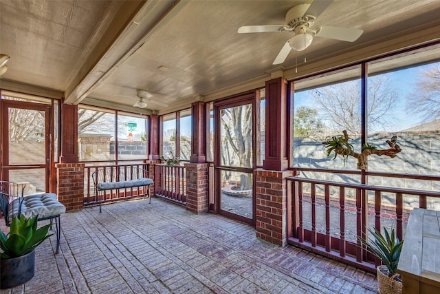 unfurnished sunroom featuring ceiling fan