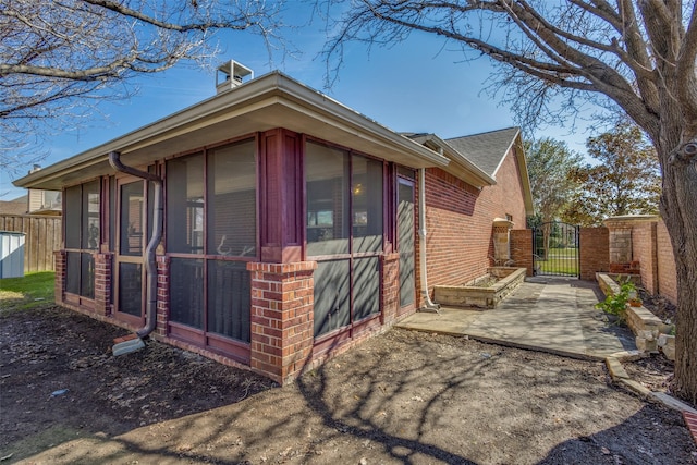 view of side of home featuring a patio and a sunroom