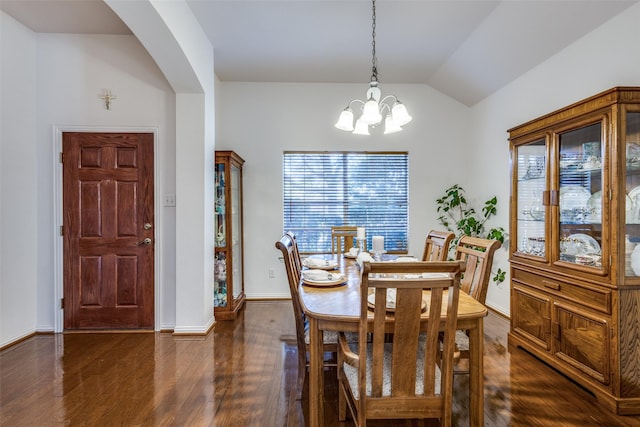 dining area featuring dark hardwood / wood-style flooring, a notable chandelier, and lofted ceiling