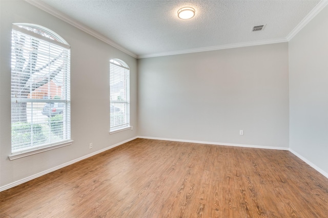 unfurnished room featuring wood-type flooring, ornamental molding, and a textured ceiling