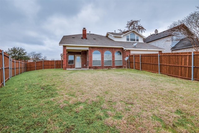 rear view of property with a lawn