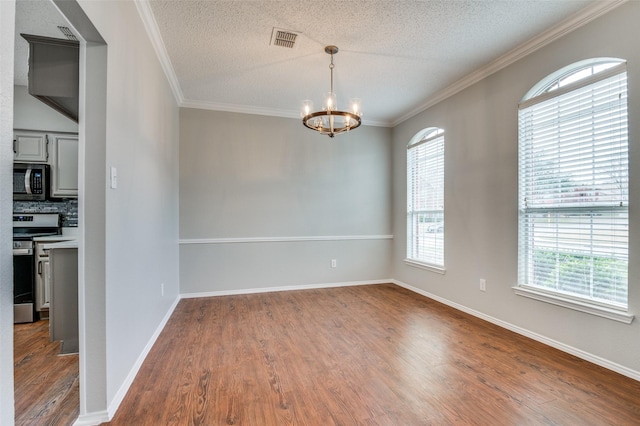 unfurnished room with dark wood-type flooring, ornamental molding, an inviting chandelier, and a textured ceiling