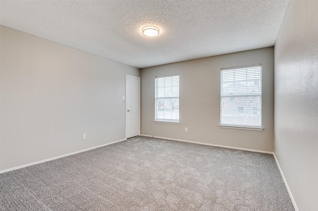 carpeted spare room with a textured ceiling