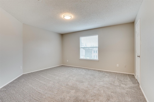 spare room featuring light carpet and a textured ceiling