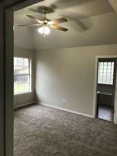 carpeted empty room featuring lofted ceiling and ceiling fan