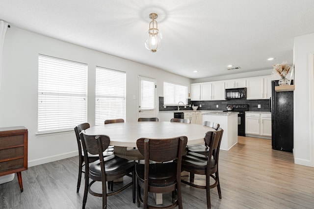 dining area featuring sink and light hardwood / wood-style floors