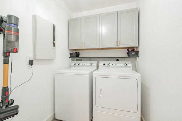 laundry room featuring washer and clothes dryer and cabinets