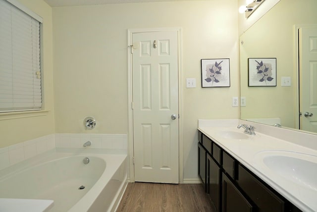 bathroom featuring vanity, hardwood / wood-style floors, and a tub to relax in