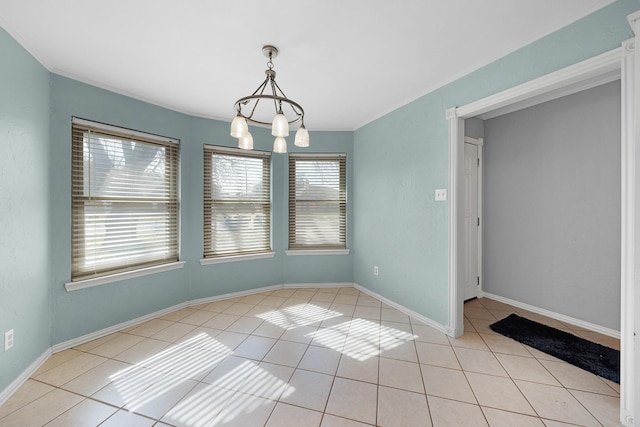 empty room featuring ornamental molding, light tile patterned floors, and an inviting chandelier