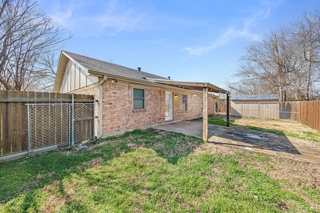 rear view of house with a lawn and a patio