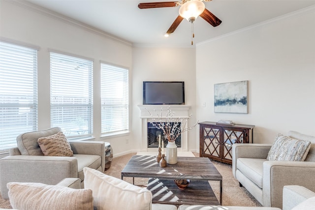 living area with a high end fireplace, baseboards, ceiling fan, light colored carpet, and ornamental molding