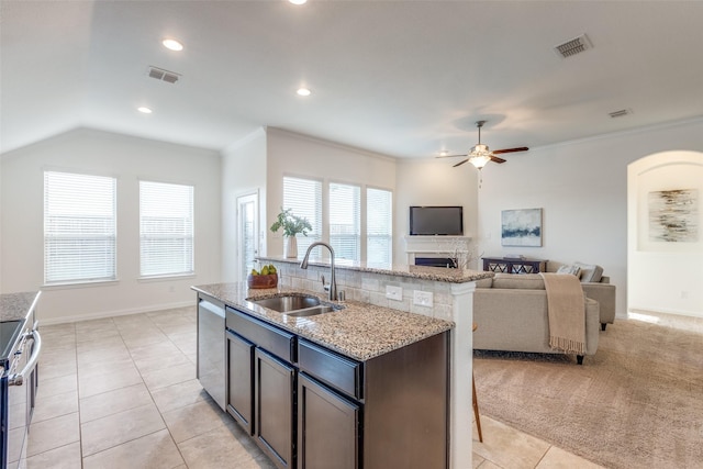 kitchen with visible vents, a sink, light stone counters, appliances with stainless steel finishes, and a fireplace