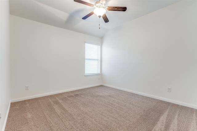 empty room featuring carpet flooring, ceiling fan, baseboards, and vaulted ceiling