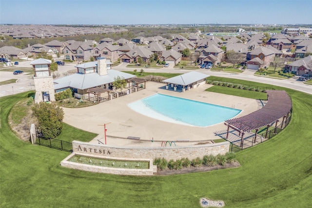 view of swimming pool featuring a yard, fence, and a residential view