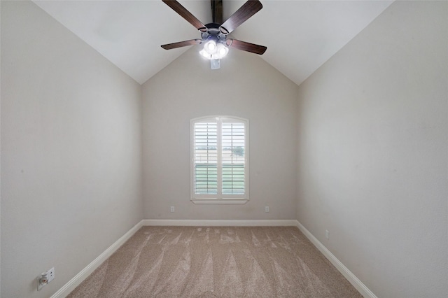 spare room with ceiling fan, baseboards, vaulted ceiling, and light colored carpet