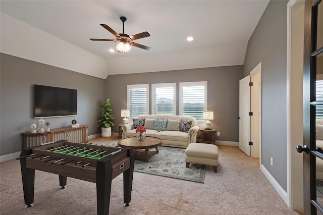 living room with lofted ceiling, light carpet, and baseboards